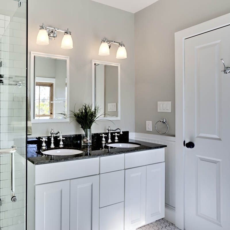 A remodeled bathroom with white vanity and walk-in shower